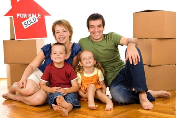 Happy family with cardboard boxes moving in a new home